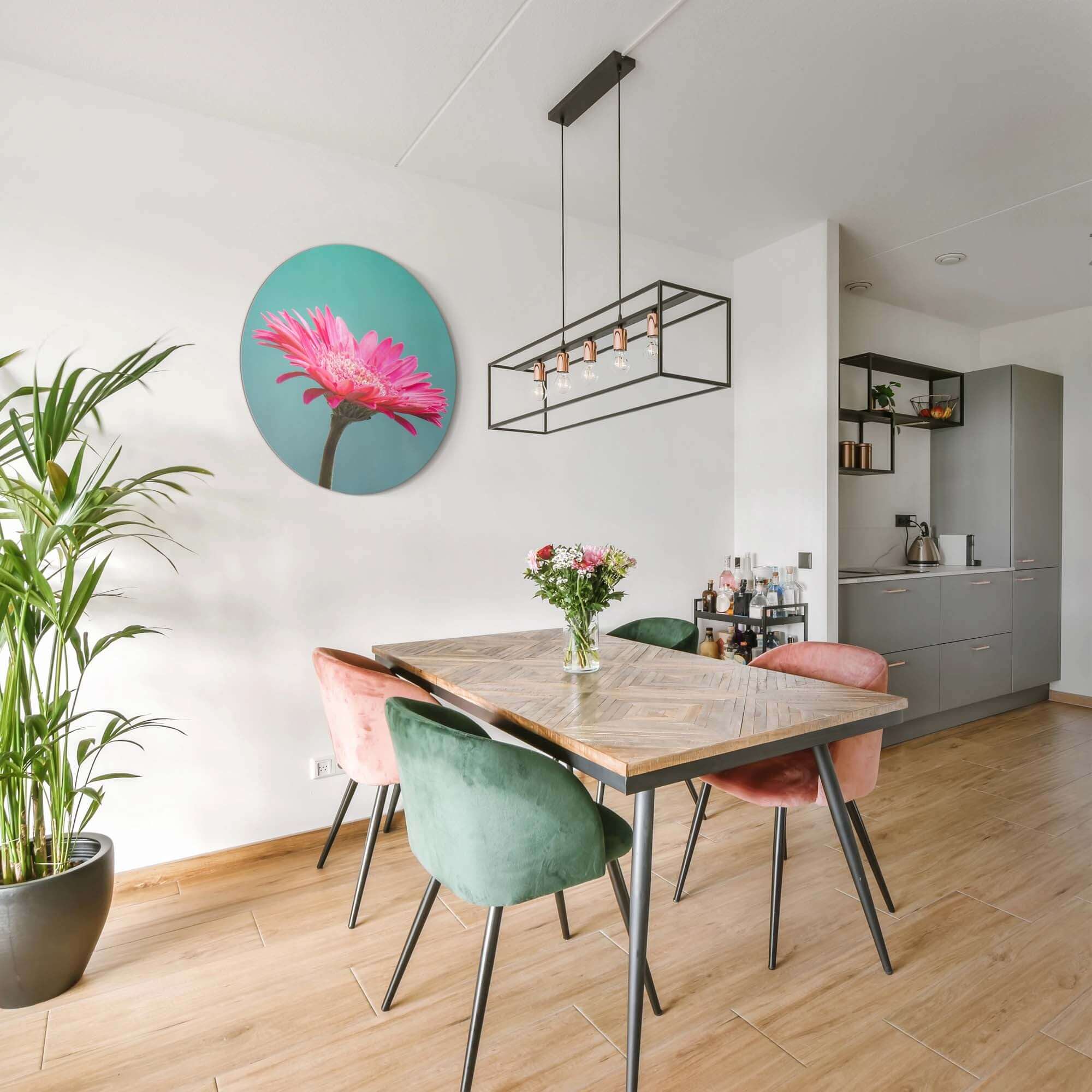Blush Bloom - Wandbild an der Wand über einem modernen Esstisch mit bunten Stühlen und einer grünen Pflanze.