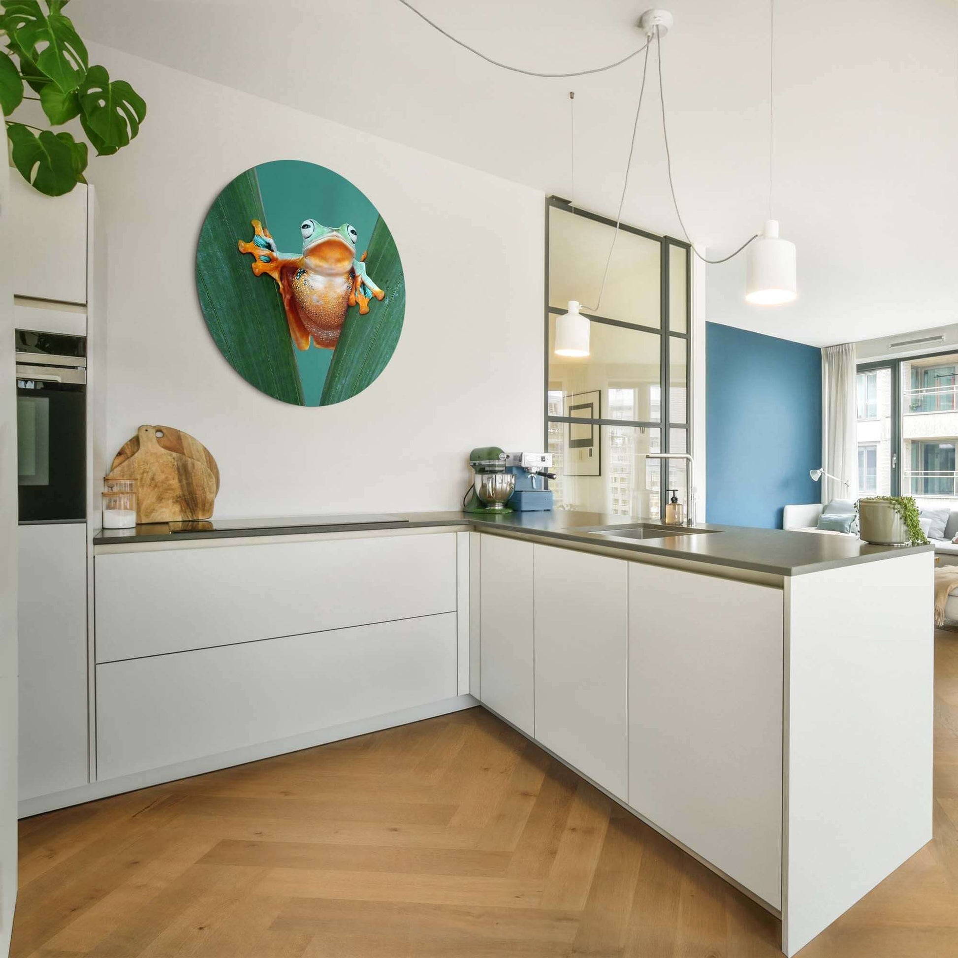 Jungle Leap - Wandbild in moderner Küche mit grünen Blättern und bunter Froschdekoration.