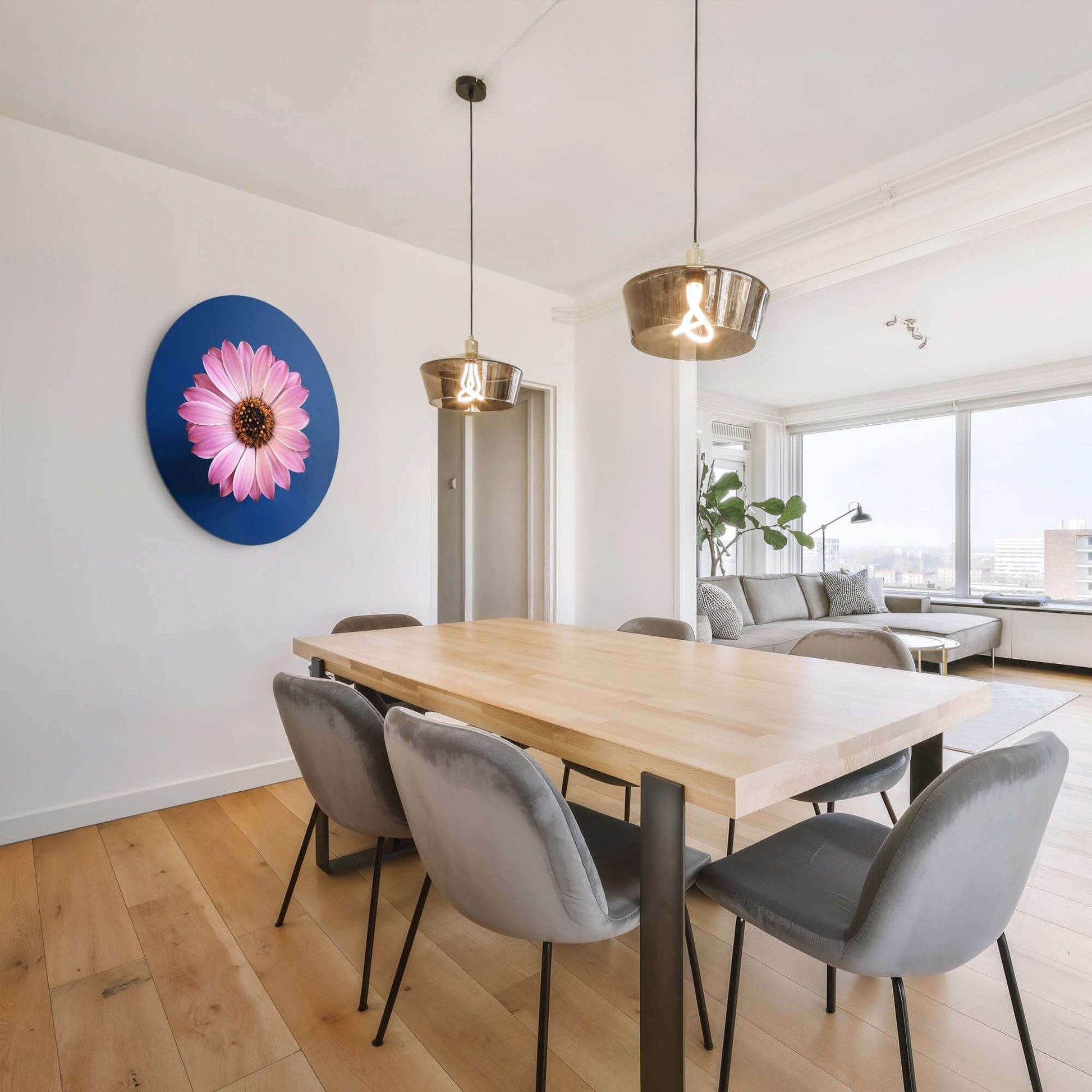 Pastellfarbenes Gänseblümchen - Wandbild an der Wand eines modernen Esszimmers mit Holztisch und bequemen Stühlen.