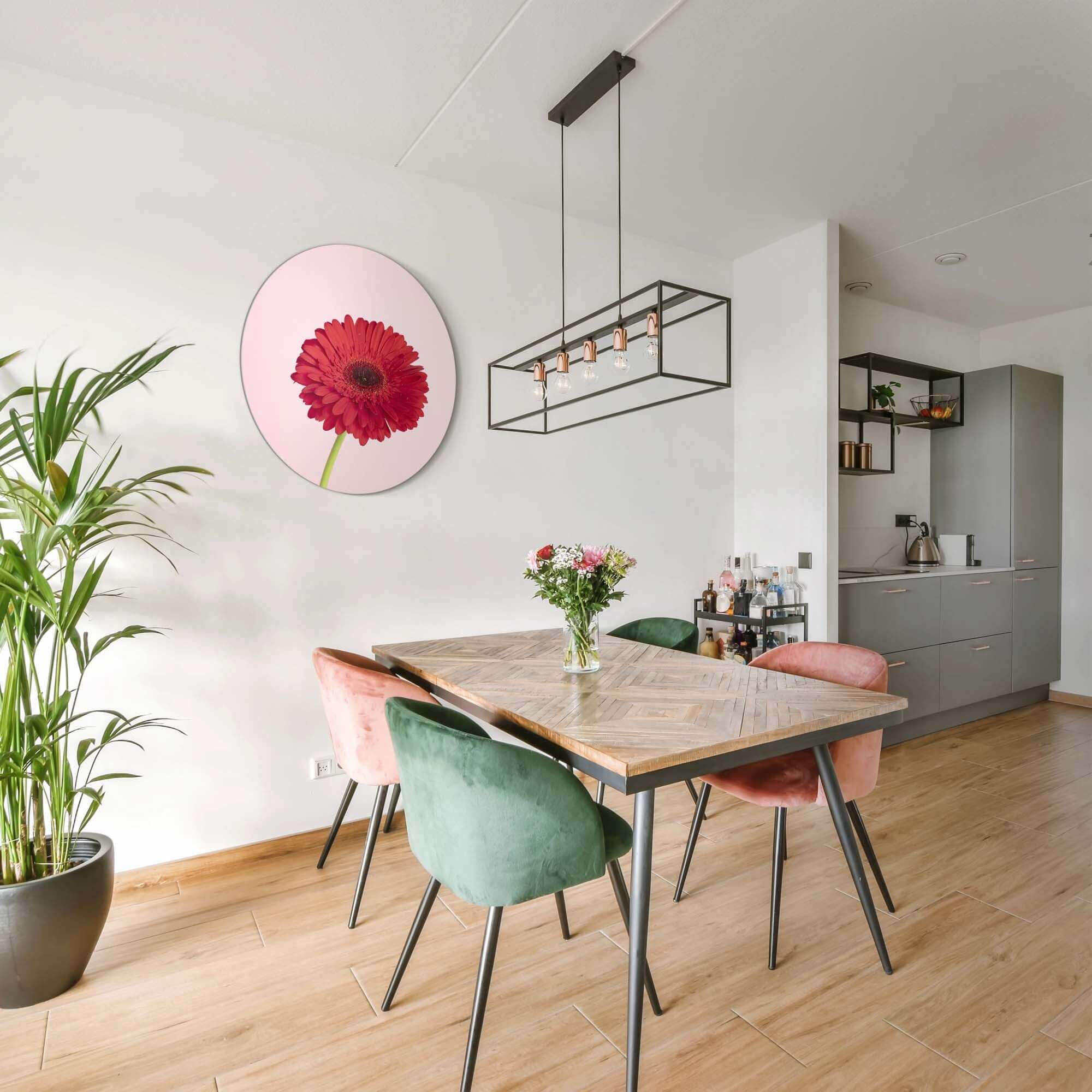 Rote Gerbera - Wandbild auf zartrosa Hintergrund im modernen Esszimmer mit Holztisch.